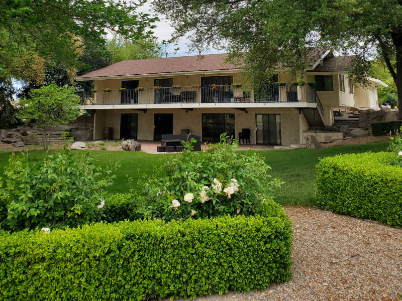 Fasi residence a 2 story house with green lawns and bushes surrounding it