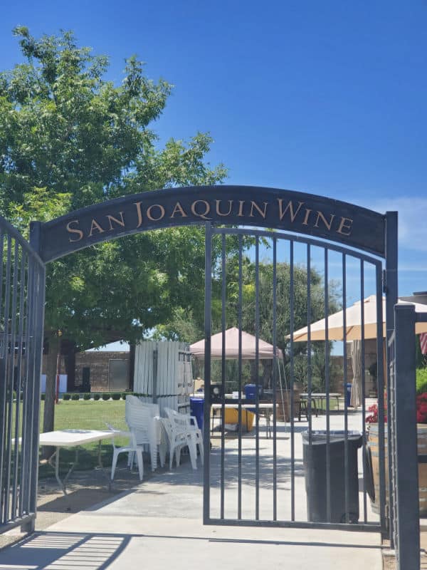 San Joaquin Wine arched entrance way with umbrellas and chairs in the background