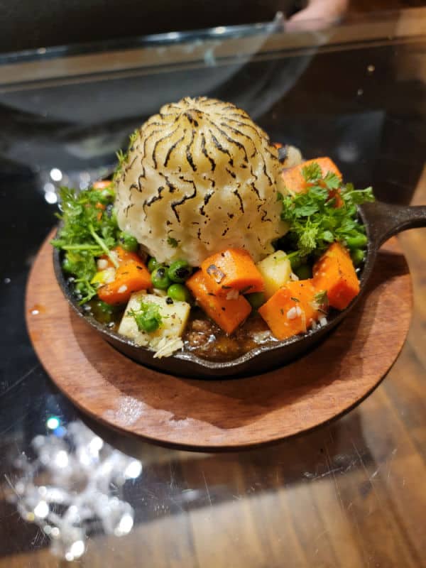 Shepherd's Pie in a cast iron skillet on a wood table at Cowboy Tavern near Oakhurst, California