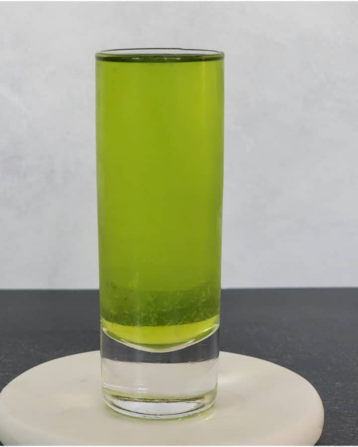 Broken Down Golf Cart green shot in a glass on a coaster