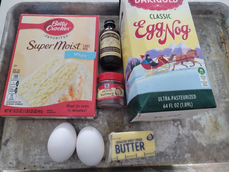 Eggnog Cookie ingredients white cake mix, vanilla, ground nutmeg, eggnog, eggs, butter on a silver baking sheet