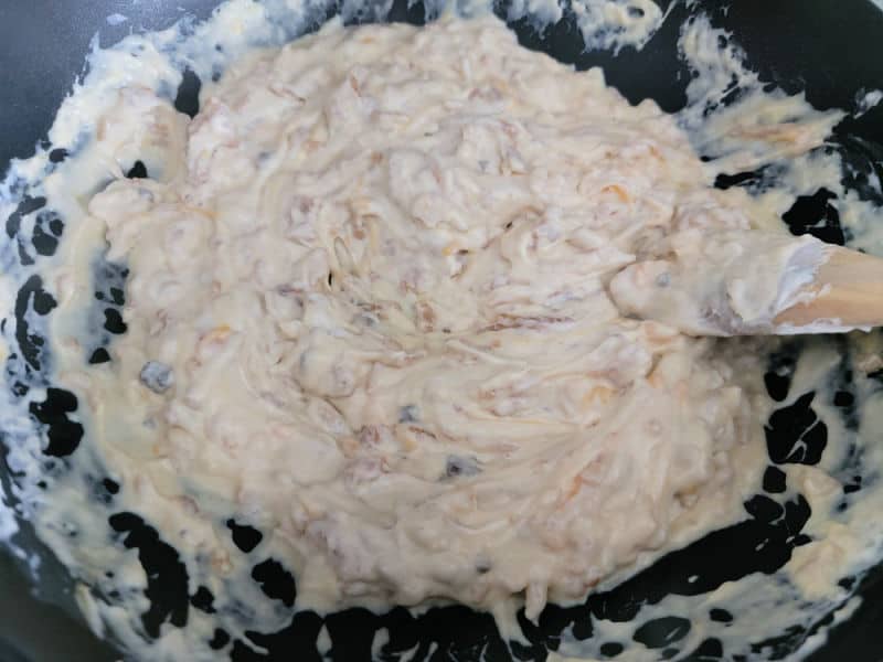 Creamy mixture cooking for broccoli casserole in a frying pan