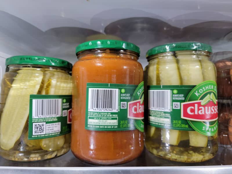 taco pickles in a jar in the refrigerator with other dill pickles