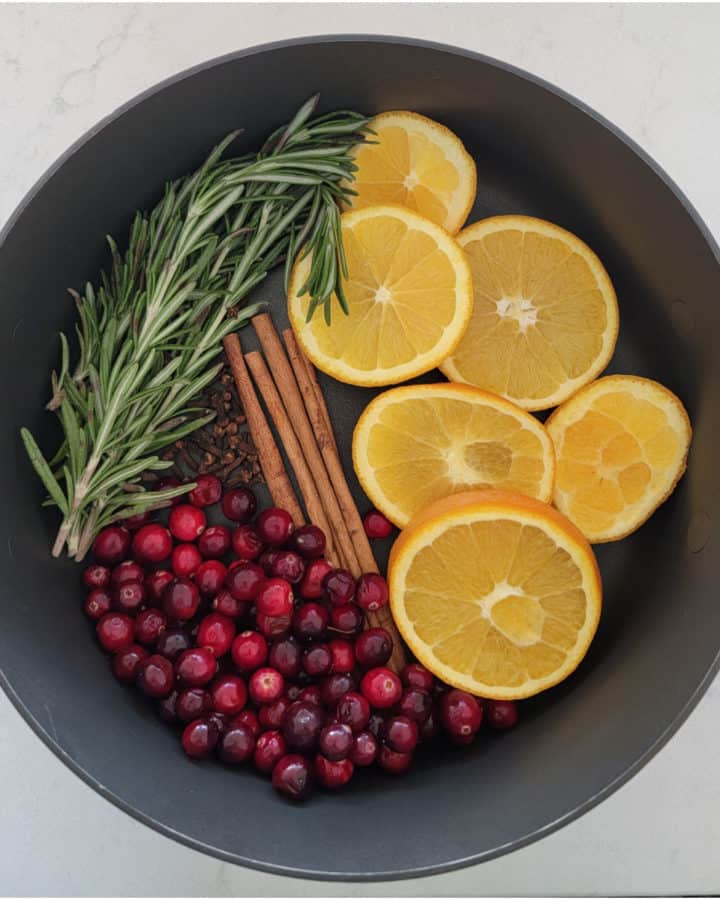 pot filled with Christmas potpourri cranberries, orange slices, cinnamon, cloves and more