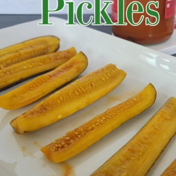 Taco Pickles spread out on a white platter with a jar of pickles behind them.