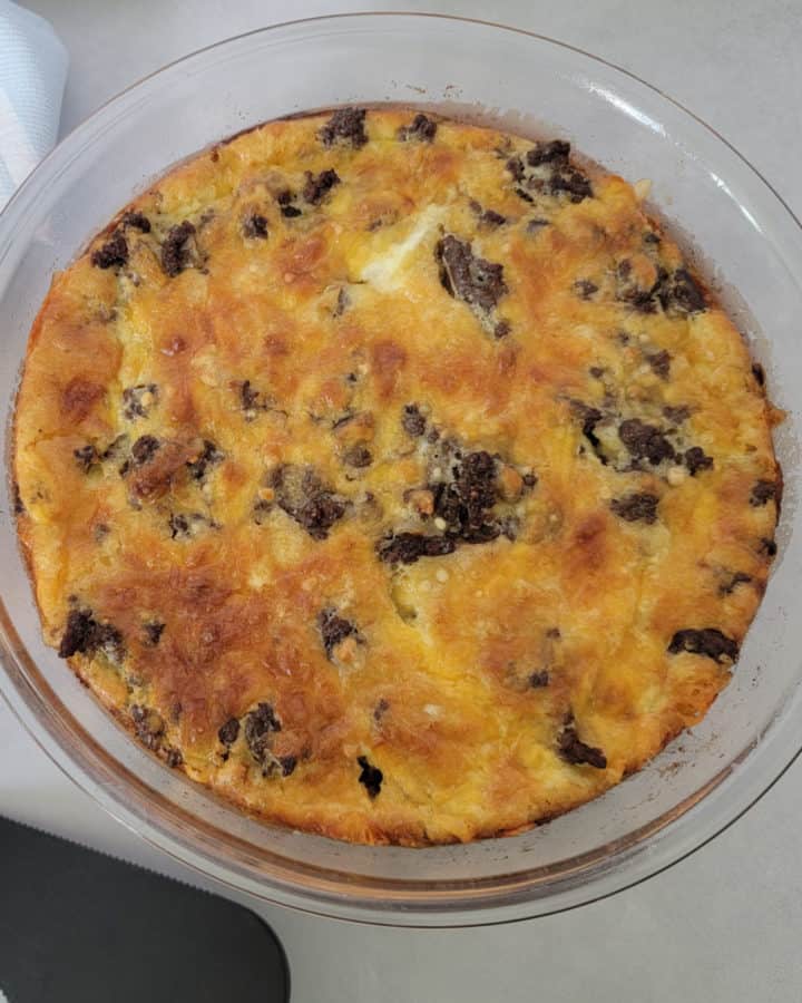 Bisquick Impossible Cheeseburger Pie in a glass pie pan with a spatula