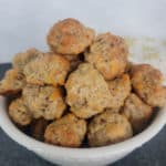 White bowl filled with Cheddar Bay Sausage Balls next to a cloth napkin