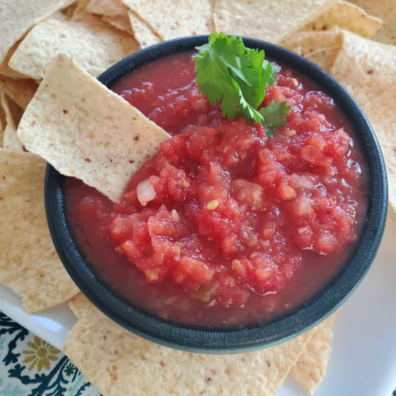 Chili's salsa in a black bowl surrounded by tortilla chips