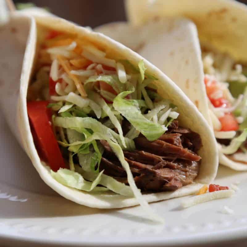 Shredded chipotle beef in a tortilla with shredded lettuce and tomato