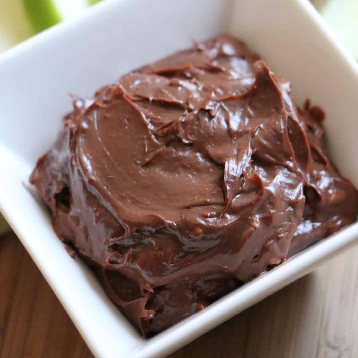 Edible Brownie Batter in a white bowl next to apple slices