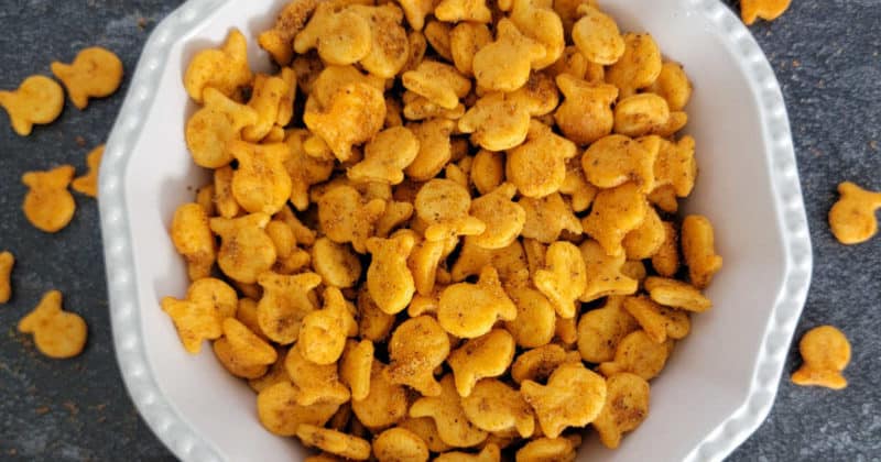 Old Bay Goldfish Crackers text printed over a large white bowl filled with Goldfish Crackers and a container of Old Bay Seasoning