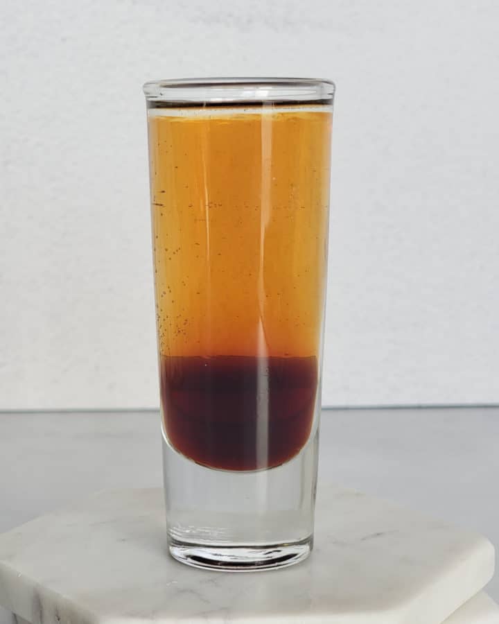 Layered mind eraser shot in a glass on coasters