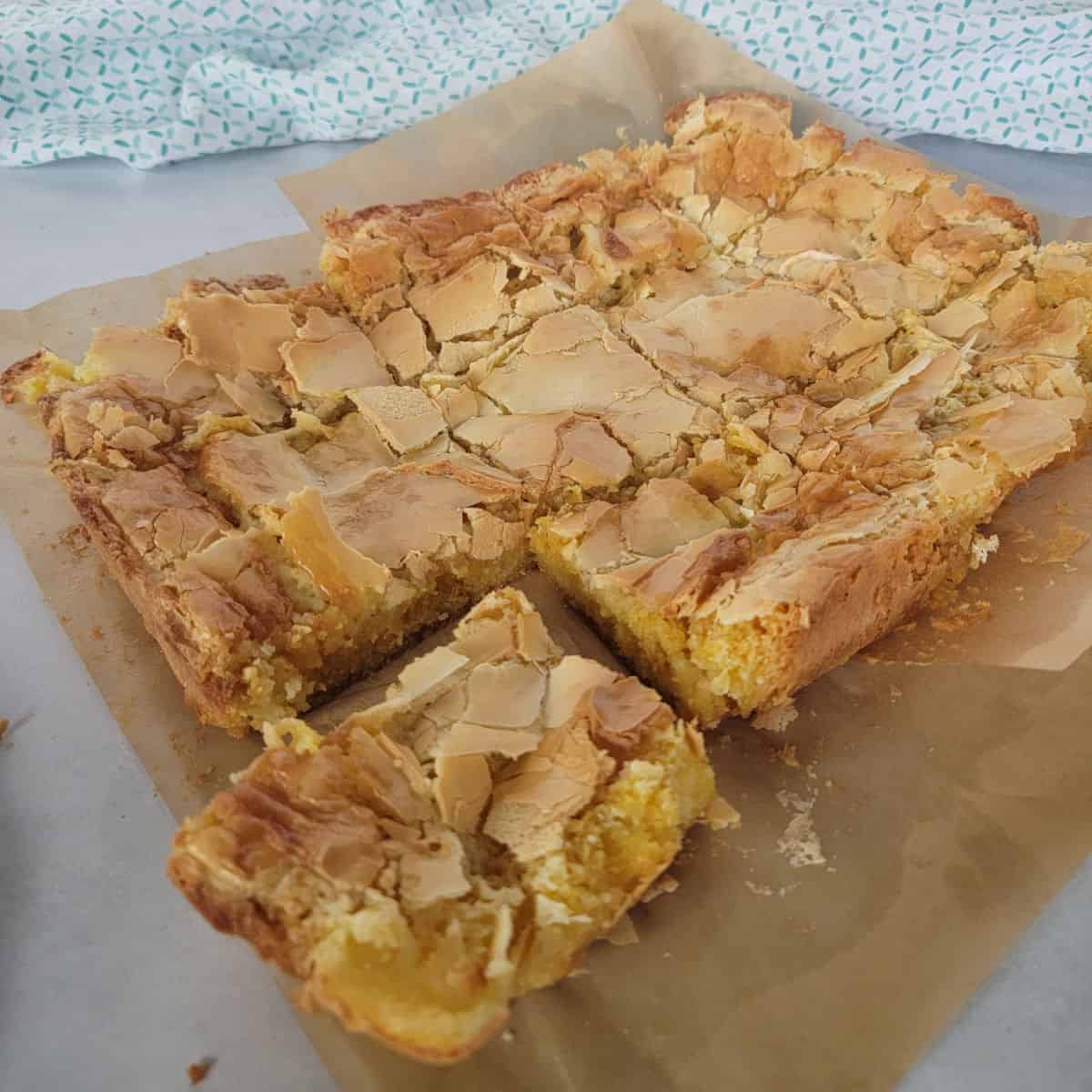 Ooey Gooey Butter Cake recipe on parchment paper with a cloth napkin