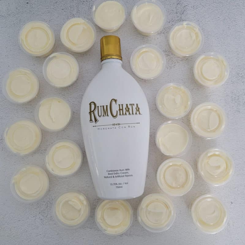 RumChata Pudding Shots spread around a bottle of RumChata