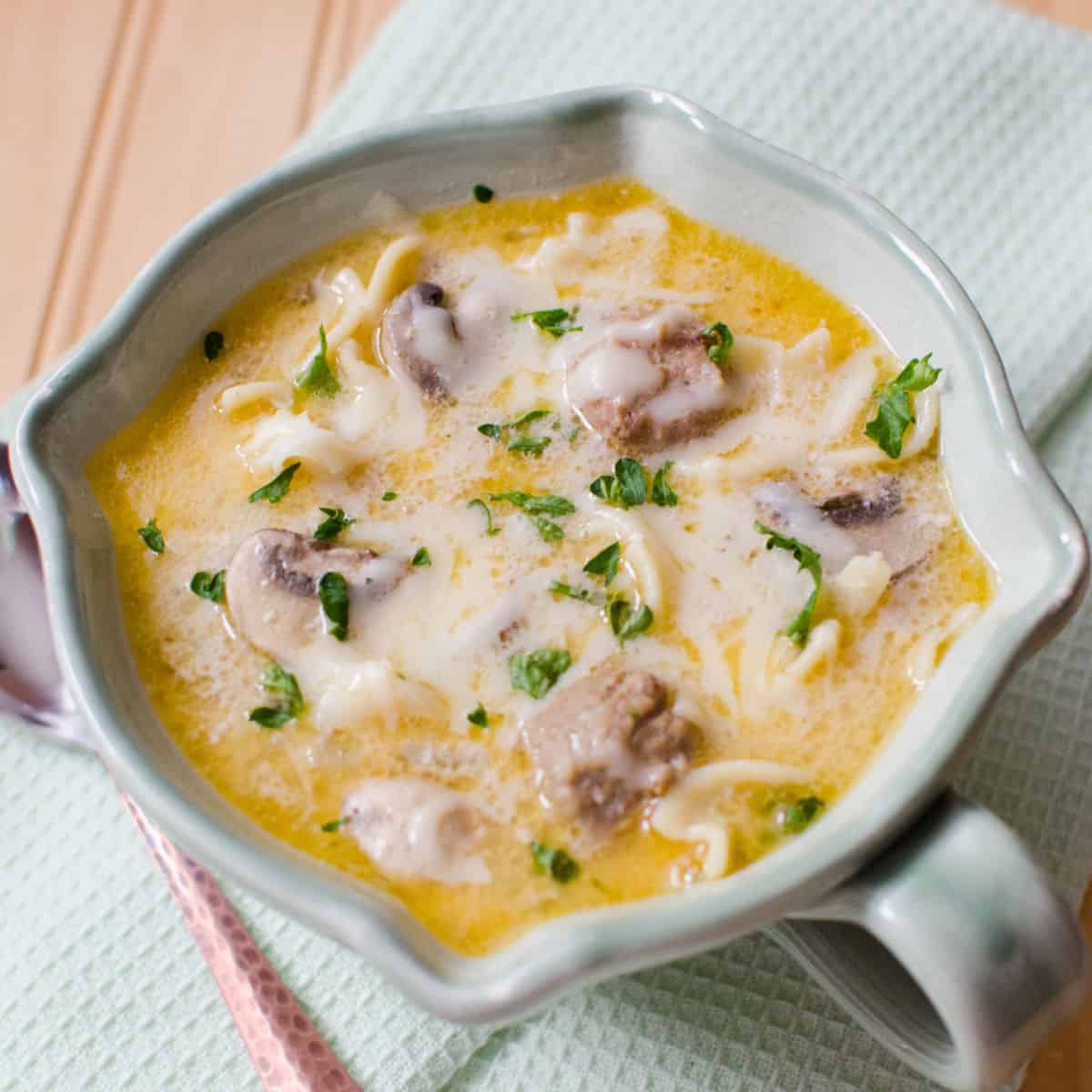 Crockpot Meatball Stroganoff Soup in a white bowl on a cloth napkin