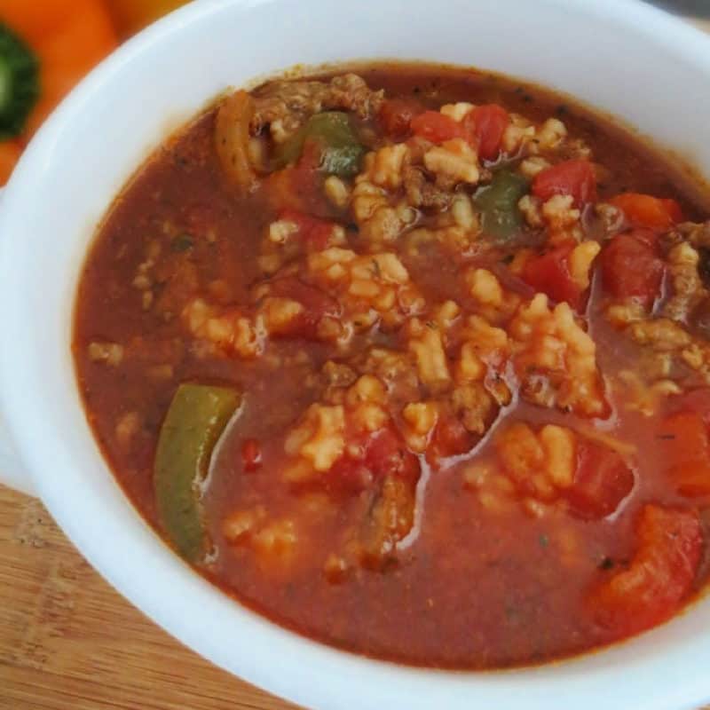 Crockpot Stuffed Pepper Soup in a white bowl with peppers in the background