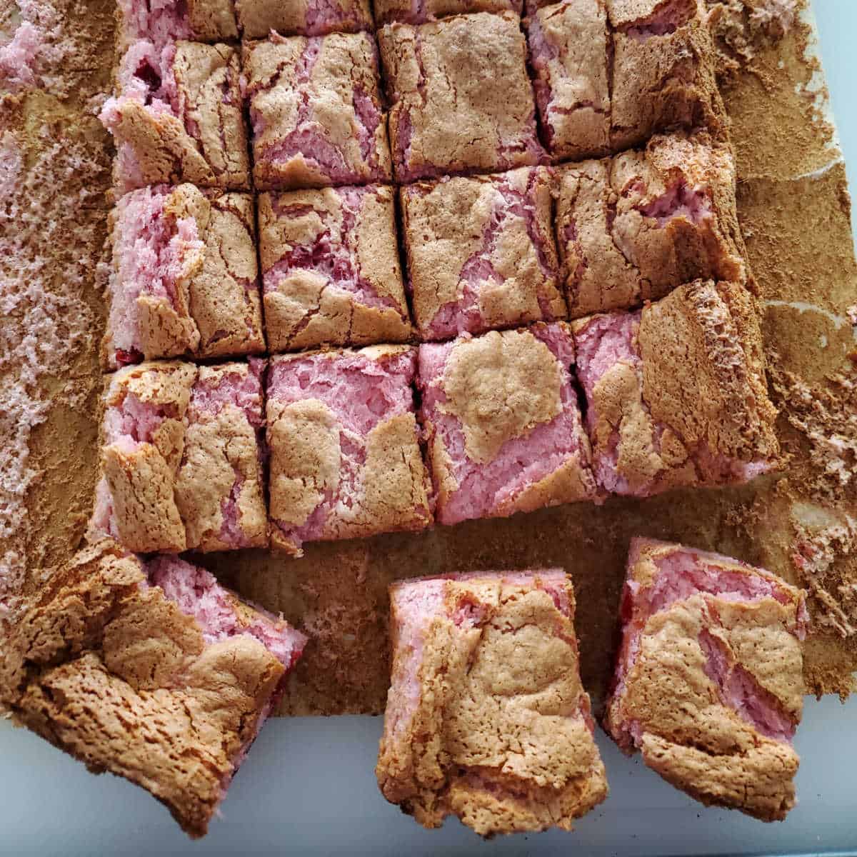 cherry angel bars on parchment paper cut into squares