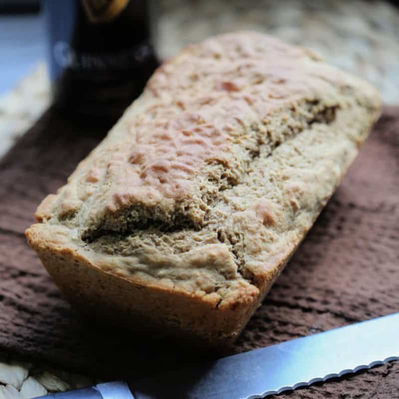 Guinness beer bread next to a knife on a brown cloth napkin