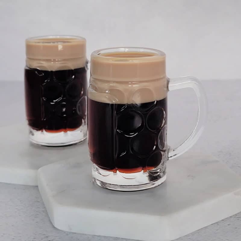 Two baby Guinness shots on white coasters