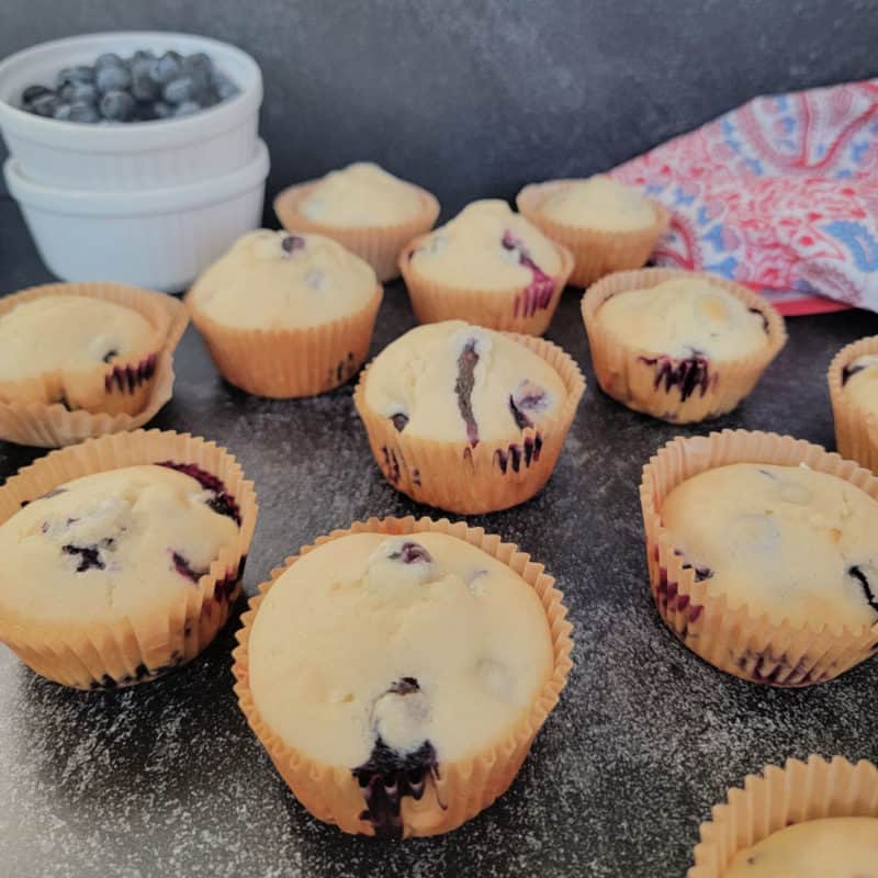 Bisquick Blueberry Muffins by a bowl of blueberries