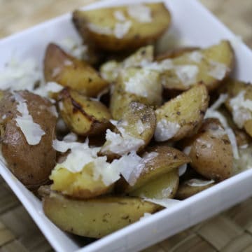 parmesan potatoes in a white bowl