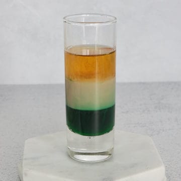 Irish Flag layered shot in a glass shot glass on a marble coaster