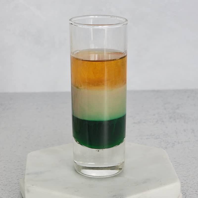 Irish Flag layered shot in a glass shot glass on a marble coaster