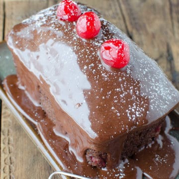 mini black forest cake garnished with maraschino cherries on a small plate