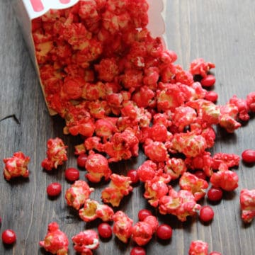 Red Hot Popcorn pouring out of a popcorn container