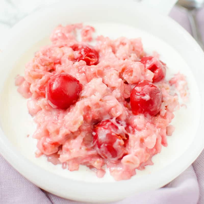 Cherry oatmeal with cherries and cream in a white bowl