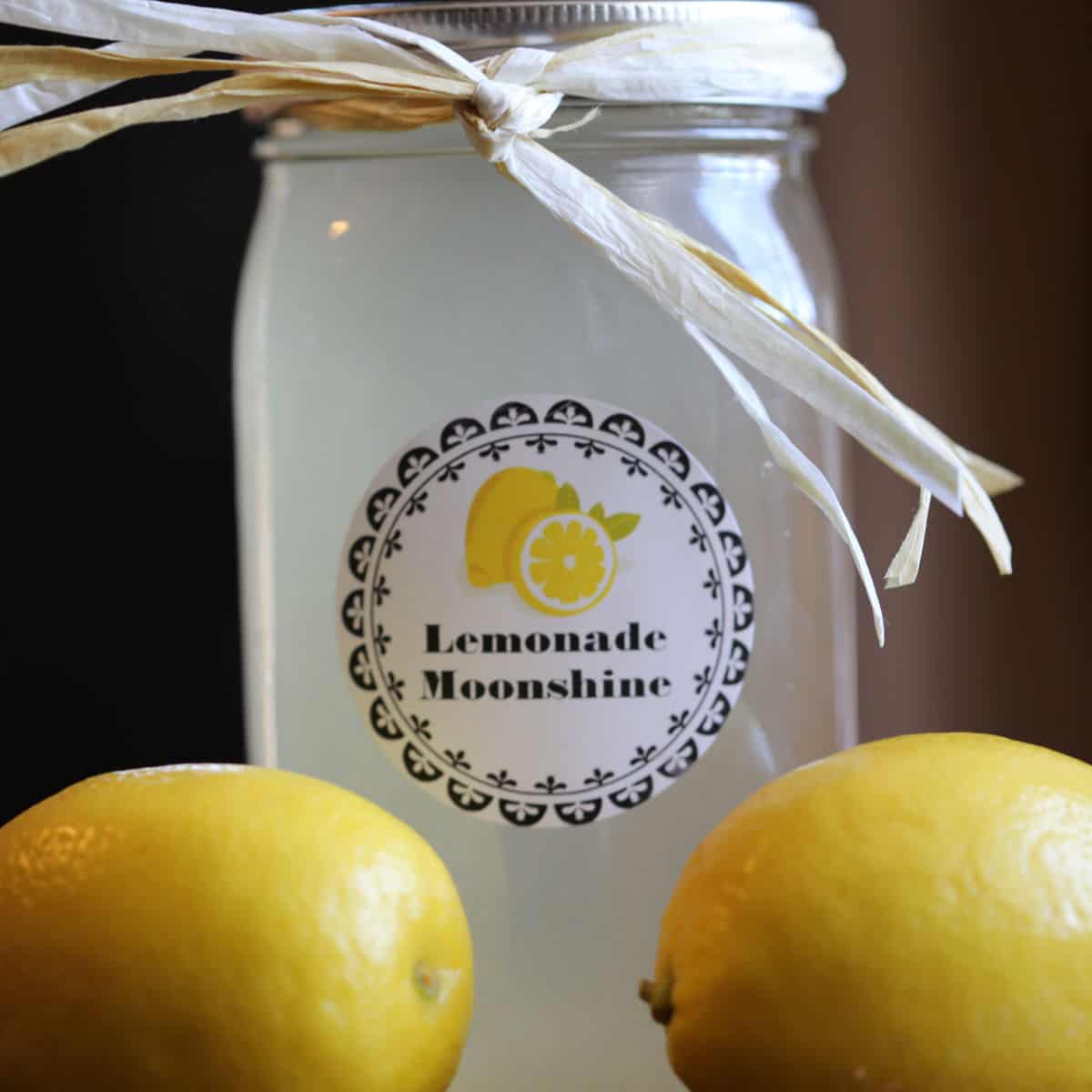 Lemonade moonshine in a mason jar with two lemons