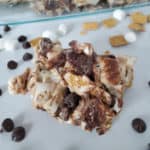 S’mores Golden Graham Bar in front of a baking dish with chocolate chips and marshmallows