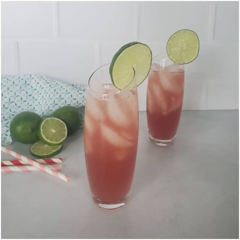 Two Bay Breeze Cocktails with lime circles next to a few limes