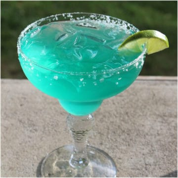 Blue agave margarita in a margarita glass with lime wedge