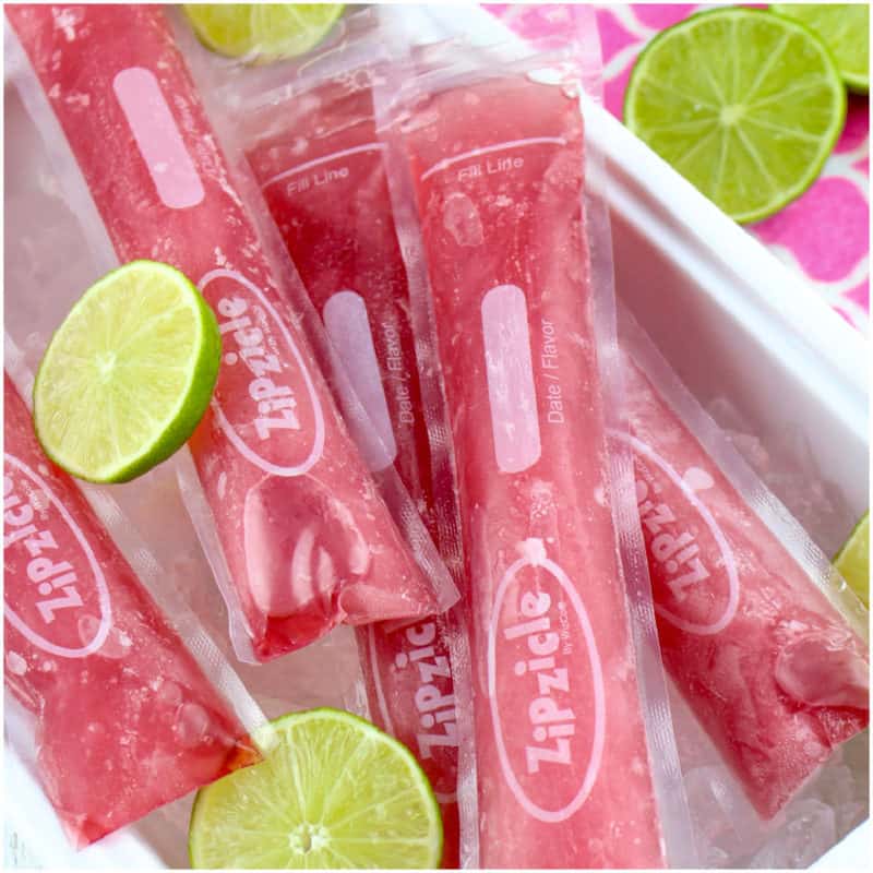 Pink popsicles in zipzicle bags on ice with limes