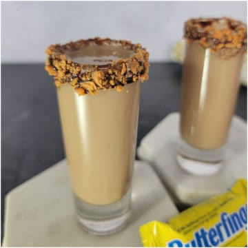 Butterfinger shot with butterfinger chocolate candy bar rimming the shot glasses