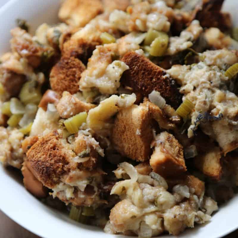 Crockpot dressing with bread and celery in a white bowl