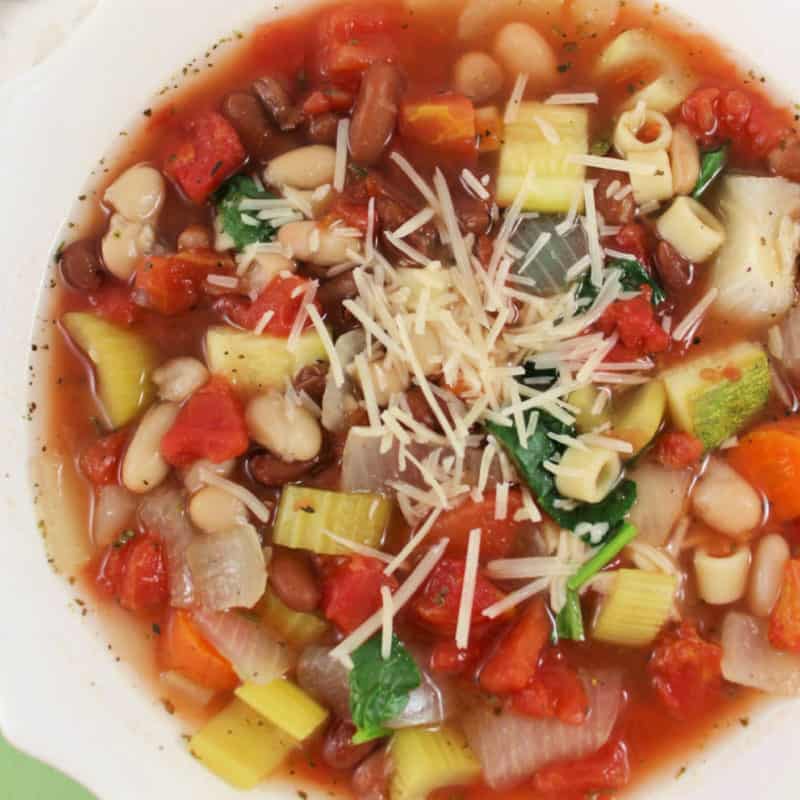 Olive Garden Minestrone soup with parmesan topping in a white bowl