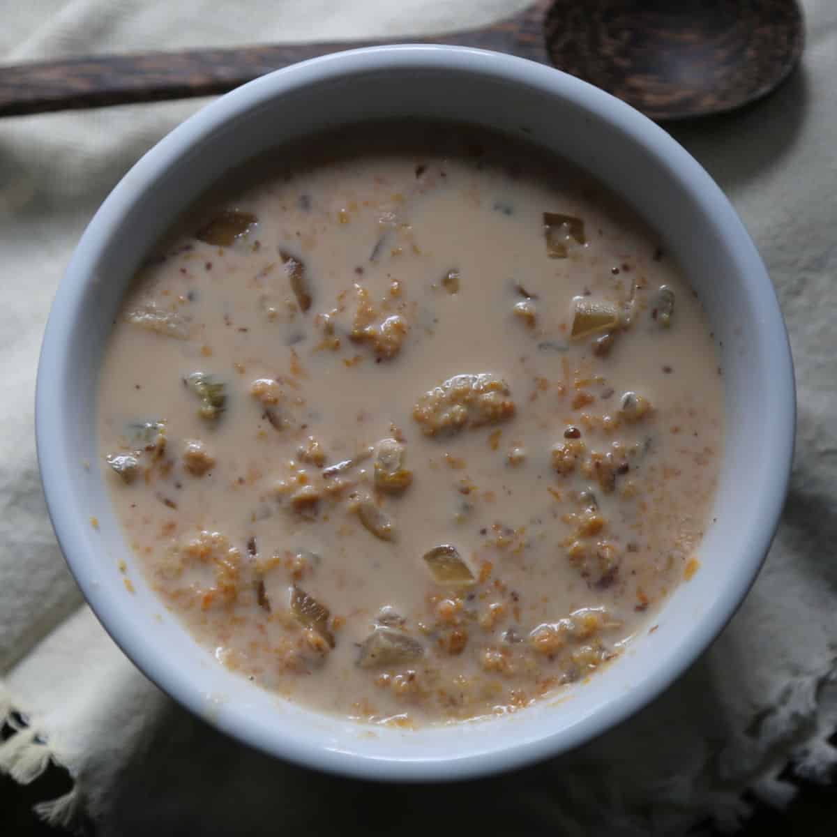 Sweet Potato Stew in a white bowl with a wooden spoon