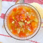 Crockpot vegetable soup in a glass bowl on a cloth napkin