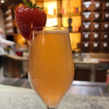 French Kiss cocktail in a champagne flute with a strawberry garnish