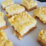 Squares of Lemon Cheesecake Bars on a white platter