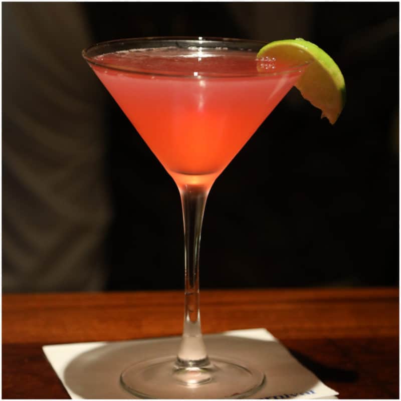 Pink martini in a martini glass with lime wedge