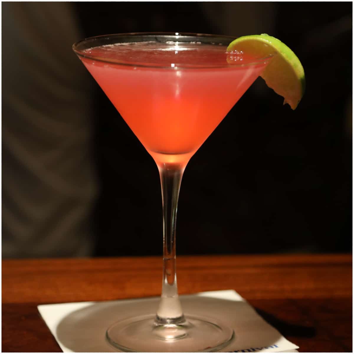 Pink martini in a martini glass with lime wedge