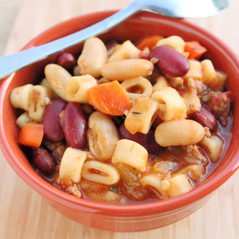 beans and round pasta in an orange bowl for pasta e fagioli soup