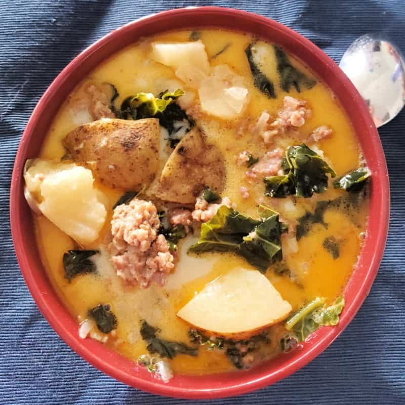 Olive Garden Zuppa Toscana Soup with ground beef, potatoes, onions, and kale in a red bowl