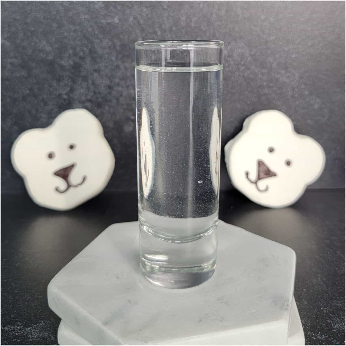 polar bear marshmallows behind a shot glass with clear liquid polar bear shot