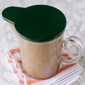Pork Bone broth in a glass container with green lid