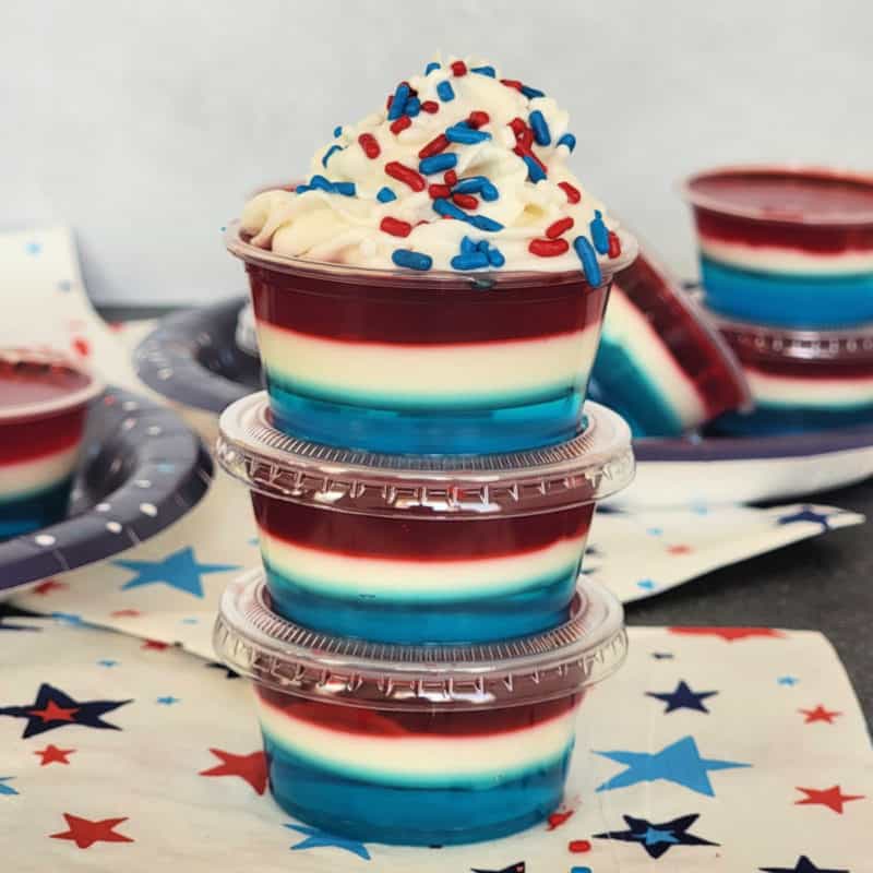 Red white and blue jello shots in plastic cups on star napkins