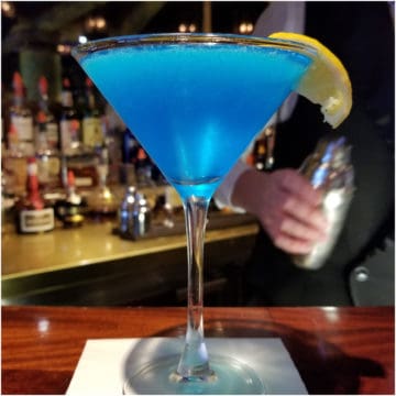Sea Blue Martini in a martini glass with lemon wedge